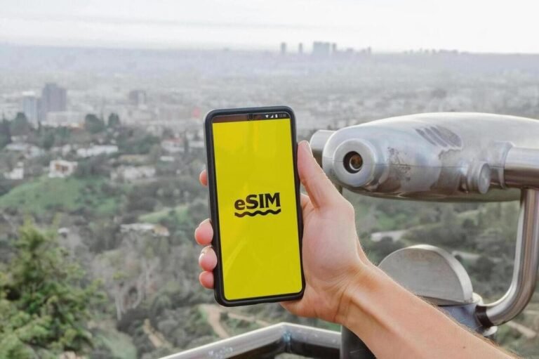 esim vs sim - una mano che tiene un telefono con sfondo una città